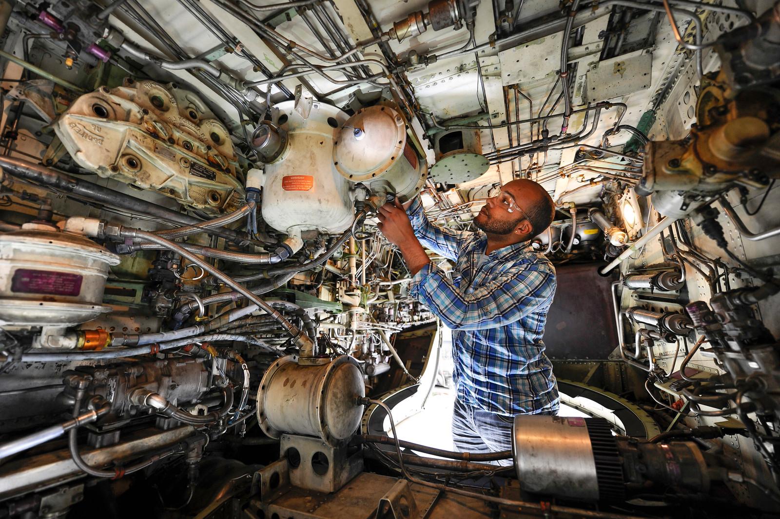 An aviation maintenance student fixing part of an airplane