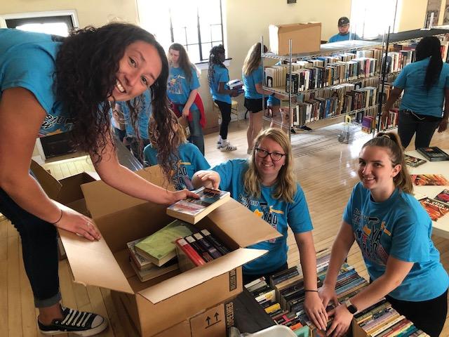 Day of Caring volunteers putting old books in boxes